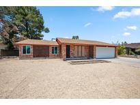 Charming single-story brick home with a well-maintained front yard and a two-car garage at 7430 E Ed Rice Ave, Mesa, AZ 85208