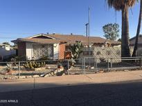 Charming single-story home with desert landscaping, complete with cacti and decorative rock, behind a gray chain-link fence at 8507 E Rancho Vista Dr, Scottsdale, AZ 85251