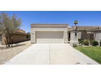 A well-maintained two-car garage with a clean, concrete driveway and desert landscaping at 10538 E Gold Dust Cir, Scottsdale, AZ 85258