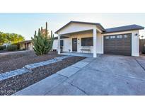 Charming home featuring a covered front porch, low maintenance desert landscaping and attached garage at 13614 N 38Th Pl, Phoenix, AZ 85032