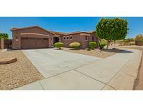 Well-maintained home featuring a landscaped front yard and a spacious driveway leading to a two-car garage at 16259 W Papago St, Goodyear, AZ 85338