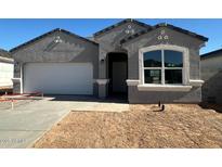 Charming single-story home featuring a two-car garage, neutral stucco, and a well-manicured yard at 18331 W Hackamore Dr, Wittmann, AZ 85361