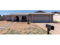 Charming single-story home with a well-maintained front yard and a two-car garage at 2233 W Oraibi Dr, Phoenix, AZ 85027