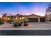 Southwestern home with desert landscaping, a three car garage, and a sunset backdrop at 28768 N 95Th Way, Scottsdale, AZ 85262
