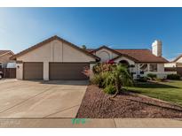 Charming single-story home featuring a terracotta roof, lush landscaping, and a spacious three-car garage at 3054 E Norwood St, Mesa, AZ 85213