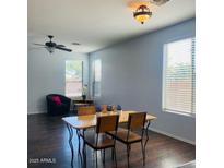 Bright dining room with wood floors, lots of natural light from windows, and modern light fixtures at 40331 N Parisi Pl, San Tan Valley, AZ 85140