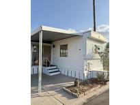 Exterior of mobile home with carport, decorative window feature and desert landscaping at 530 S Alma School Rd # 75, Mesa, AZ 85210