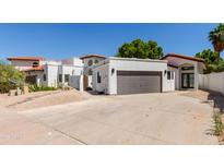 White stucco home featuring a terracotta roof, gray garage door, and low maintenance desert landscaping at 5909 E Aire Libre Ln, Scottsdale, AZ 85254