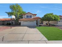 Charming two-story home featuring a red tile roof, spacious driveway with basketball hoop, and well-maintained landscaping at 7658 W Boca Raton Rd, Peoria, AZ 85381