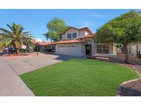 Charming two-story home boasting a red tile roof, well-manicured lawn, and desert landscaping with a palm tree at 7658 W Boca Raton Rd, Peoria, AZ 85381