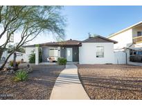 Charming single story home featuring a welcoming walkway, rock landscaping, and a light blue front door at 1512 E Cypress St, Phoenix, AZ 85006