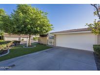Home featuring a private gated entry, two car garage and well-maintained lawn with mature landscaping at 11416 N Century Ln, Scottsdale, AZ 85254