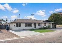 Charming single-story home featuring a well-manicured lawn and a freshly painted exterior with dark trim accents at 1421 W Pasadena Ave, Phoenix, AZ 85013