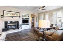 Bright living room featuring a fireplace, ceiling fan, and contemporary furnishings at 15221 N Clubgate Dr # 2096, Scottsdale, AZ 85254