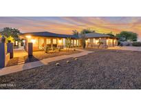 Beautiful home exterior featuring desert landscaping, gravel yard and a charming, modern design with a sunset in the background at 22039 N 86Th Ave, Peoria, AZ 85383