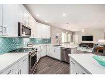 Bright kitchen with stainless appliances, white cabinets, granite countertops, and decorative tile backsplash at 2511 W Queen Creek Rd # 258, Chandler, AZ 85248