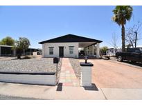 Charming home with a covered carport, mature landscaping, and a walkway leading to the front door at 2815 W Ohio St, Apache Junction, AZ 85120