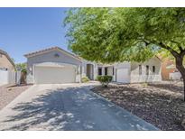 Charming single-story home featuring a three-car garage and low-maintenance desert landscaping under a sprawling, mature tree at 2976 E Clifton Ave, Gilbert, AZ 85295