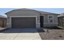 Charming single-story home featuring neutral stucco, a large garage, stone accents, and low maintenance landscaping at 35512 N Common Ct, San Tan Valley, AZ 85140