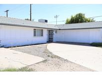 Cozy house with a gray roof, a gated front door, a garage, and a spacious driveway at 3651 W Mariposa St, Phoenix, AZ 85019