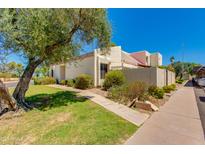 Charming single-story home with desert landscaping, mature shade tree, and covered parking at 7802 E Rovey Ave, Scottsdale, AZ 85250
