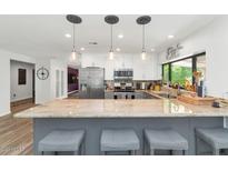 Modern kitchen with granite counters, stainless steel appliances, eat-in island, and stylish pendant lighting at 7806 N Via Del Sol --, Scottsdale, AZ 85258