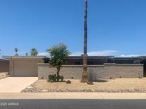 Charming single-story home featuring desert landscaping, brick accents, and a private courtyard wall at 9708 W Redwood Dr, Sun City, AZ 85351