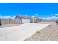 Charming home showcasing a spacious driveway and a well-maintained exterior with a modern design on a sunny day at 12940 W Tara Ln, Surprise, AZ 85374