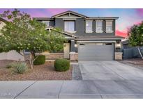 Beautiful two-story home with a gray exterior, well-kept landscaping and a spacious two car garage at 13237 W Redstone Dr, Peoria, AZ 85383