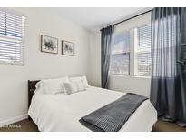 A cozy bedroom featuring neutral tones, soft bedding, and natural light from the window at 1800 S Jesse Pl, Chandler, AZ 85286