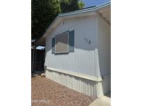 Exterior view of a charming single-story home featuring light blue siding and window shutters at 201 S Greenfield Rd # 118, Mesa, AZ 85206