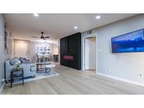 Open-concept living room with modern fireplace and light wood-look flooring at 4303 E Cactus Rd # 128, Phoenix, AZ 85032