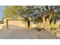Charming home featuring a two-car garage, desert landscaping, and a mature tree at 7313 S 25Th S Dr, Phoenix, AZ 85041