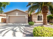 Charming single-story home featuring a manicured front yard and a two-car garage at 9465 W Tonopah Dr, Peoria, AZ 85382