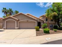 Charming two-story home showcasing a 3 car garage, desert landscaping, and tile roof at 18854 N 73Rd Dr, Glendale, AZ 85308