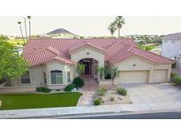 Beautiful single-story home on the golf course featuring lush desert landscaping and mature palm trees at 2053 E Clubhouse Dr, Phoenix, AZ 85048