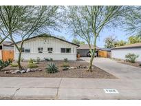 Charming white home with desert landscaping and mature trees provides curb appeal at 2109 W Berridge Ln, Phoenix, AZ 85015