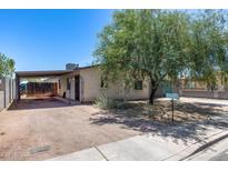 Quaint single-story home featuring a large tree, carport, and easy-to-maintain desert landscaping at 2129 N Summer St, Mesa, AZ 85203