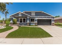 Charming home boasts manicured lawn, stone accents, and attached two car garage at 2542 E Los Alamos St, Gilbert, AZ 85295