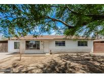 Charming single-story home featuring a brick facade, complemented by mature trees and a well-maintained lawn at 3238 W Rose Ln, Phoenix, AZ 85017