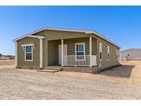 Charming, well-maintained single story home with a cozy front porch and ample natural light at 32650 N 223Rd Dr, Wittmann, AZ 85361
