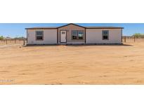Charming single-story home with white siding, black trim, and a neatly landscaped front yard at 32712 N 223Rd Dr, Wittmann, AZ 85361
