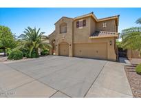 Inviting two-story home with a three-car garage and a well-maintained, desert-landscaped front yard at 5060 S Clancy --, Mesa, AZ 85212
