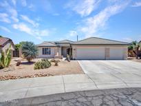 Charming home featuring desert landscaping, a three-car garage, and a tile roof at 10501 W Wilshire Dr, Avondale, AZ 85392