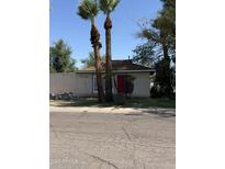 Charming single-story home featuring palm trees and a vibrant red front door at 404 W 11Th St, Tempe, AZ 85281