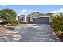 Charming single-story home with a gray stucco exterior, a two-car garage, and desert landscaping at 5345 W Alta Mesa Ave, Laveen, AZ 85339