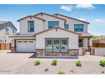 Two-story stucco home with a two-car garage, decorative stone, and a well-maintained brick paver driveway at 5917 N 83Rd Ln, Glendale, AZ 85305