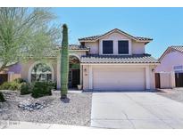 Charming two-story home featuring desert landscaping and a spacious two-car garage at 6023 E Scafell Cir, Mesa, AZ 85215