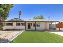 Charming single-story home featuring a modern door, new artificial turf, and a covered carport at 6813 E Diamond St, Scottsdale, AZ 85257