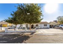 Charming single-story home featuring a well-maintained yard and an inviting entrance with mature trees at 7135 W Heatherbrae Dr, Phoenix, AZ 85033